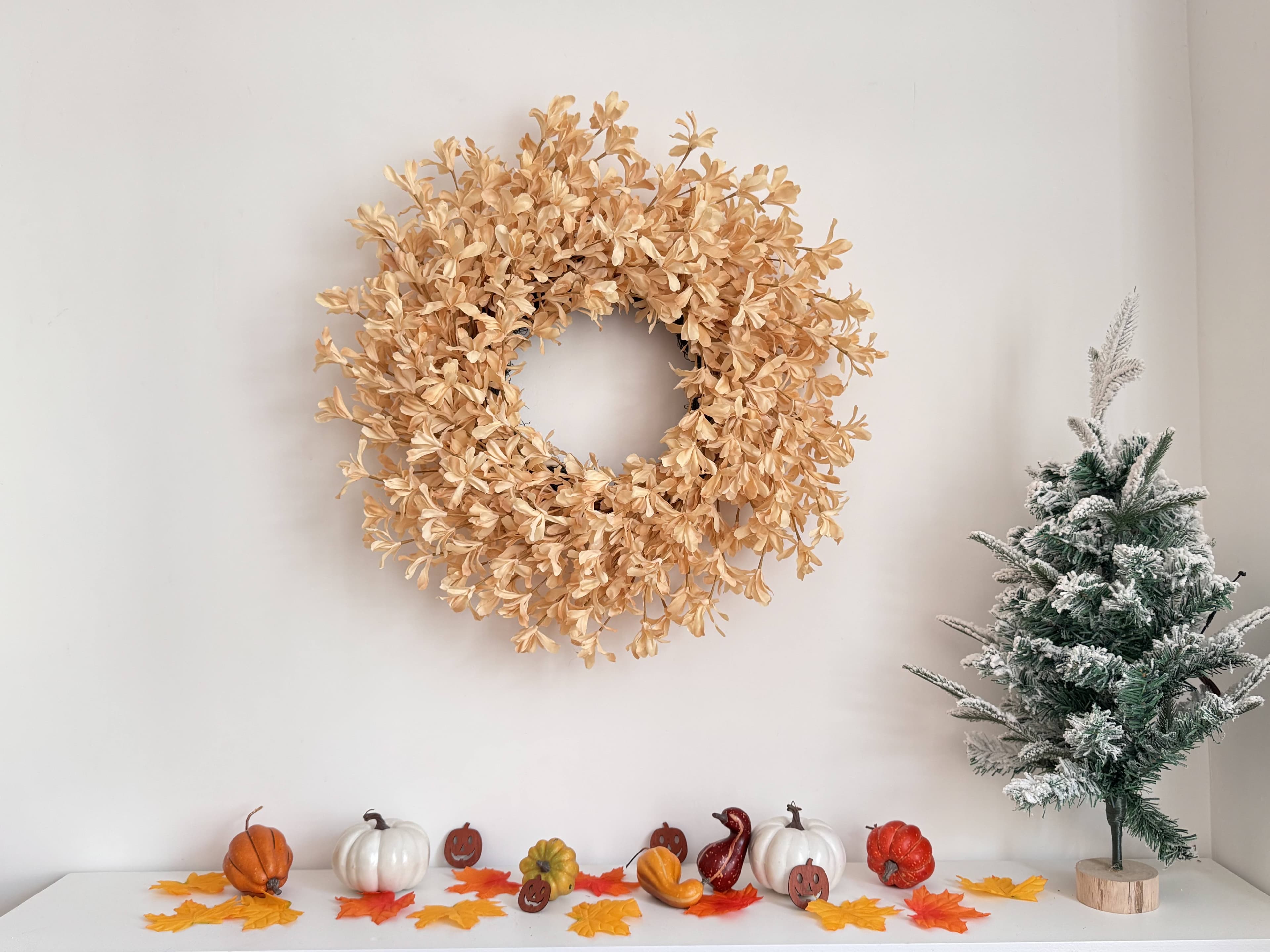 The Champagne Forsythia Wreath styled on a painted front door in soft daylight